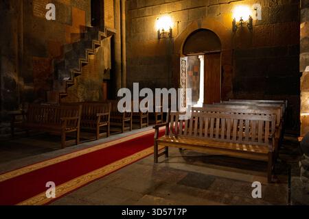 Église arménienne du monastère Hovhannavank avec un tapis rouge menant à l'autel. Les bancs sont vides. La pièce est faiblement éclairée Banque D'Images