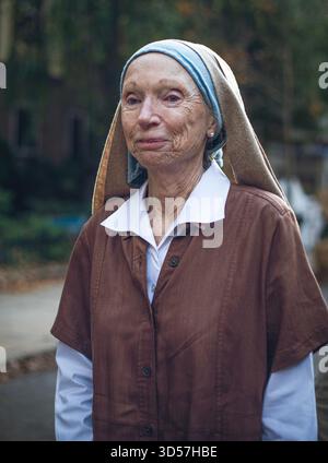 Une femme âgée se tient devant un costume d'Halloween Banque D'Images
