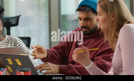 Pensive Thinking homme d'affaires informel arabe fondateur indien de démarrage de travailleur masculin travaillant avec un ordinateur portable tapant des notes dans le bureau décontracté Banque D'Images