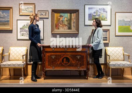 Londres, Royaume-Uni. 14 novembre 2025. Membres du personnel avec une commode Lombard exceptionnelle du début du 19ème siècle de Giuseppe Maggiolini, vers 1805-1810, (estimation £50 000 - £80,000) sous Victor Pasmore R.A. (Britannique, 1908-1998) "The Painting Lesson", 1939, (estimation £30 000 - £50,000) lors d'un aperçu de la vente Lady Glenconner, My Life in Objects à Bonhams. Lady Glenconner était demoiselle d'honneur au couronnement de la reine Elizabeth II en 1953, et Lady in Waiting de son amie d'enfance, la princesse Margaret. Les lots seront mis aux enchères dans les galeries Bonhams New Bond Street le 18 novembre. Crédit : Stephen Chung Banque D'Images