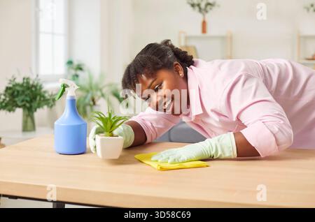 Table d'essuyage afro-américaine de femme de ménage avec un tissu jaune, gros plan Banque D'Images
