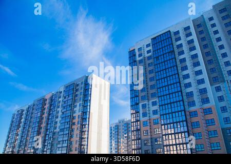 Bâtiments résidentiels modernes avec des façades en verre et des façades colorées contre un ciel bleu vif Banque D'Images