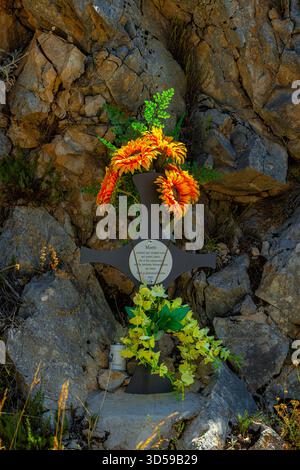 Un mémorial en bord de route commémorant un accident tragique, commémorant une victime avec des fleurs et une plaque commémorative sur les rochers, Abruzzes, Italie, Europe Banque D'Images