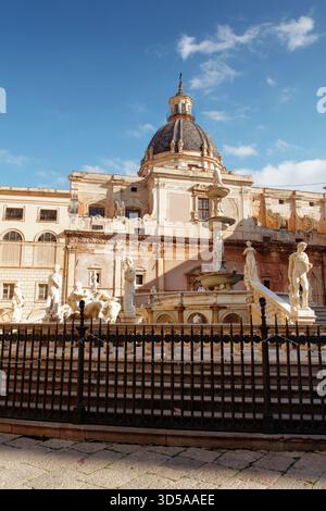 place historique ensoleillée avec une grande fontaine au milieu d'élégantes statues et d'un bâtiment baroque couvert d'un dôme. Pierre chaude, ciel bleu, et sculpture classique creat Banque D'Images