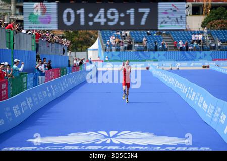 Hong Kong, Chine. 15 novembre 2025. Oscar Coggins, de Hong Kong, accueille les spectateurs tout en franchissant la ligne d'arrivée lors du triathlon individuel masculin aux 15es Jeux nationaux de Chine à Hong Kong, dans le sud de la Chine, le 15 novembre 2025. Crédit : Wu lu/Xinhua/Alamy Live News Banque D'Images