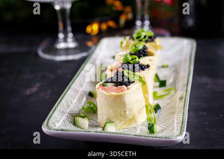 Canapés apéritif avec saumon et caviar noir sur la table de Noël. Canapés avec poisson et caviar. Banque D'Images