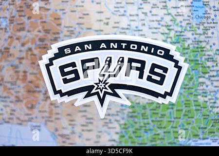 KIEV, UKRAINE - 23 FÉVRIER 2025 L'écusson de l'équipe de basket-ball San Antonio Spurs se trouve sur la bannière de fond de la carte des États-Unis Banque D'Images
