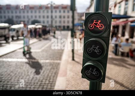 Un cycliste Glovo passant par un feu vert sur la piste cyclable, Lisbonne, Portugal. Banque D'Images