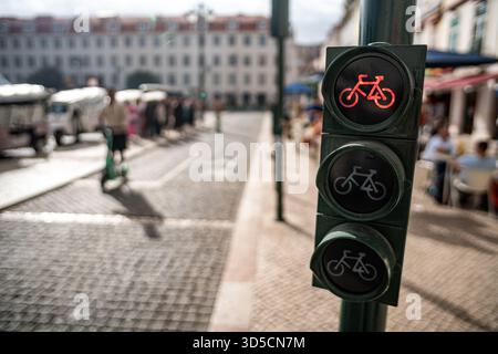 Un cycliste Glovo passant par un feu vert sur la piste cyclable, Lisbonne, Portugal. Banque D'Images