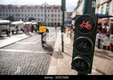 Un cycliste Glovo passant par un feu vert sur la piste cyclable, Lisbonne, Portugal. Banque D'Images