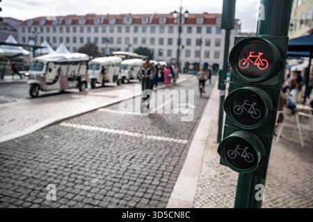 Un cycliste Glovo passant par un feu vert sur la piste cyclable, Lisbonne, Portugal. Banque D'Images