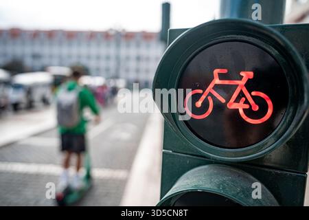 Un cycliste Glovo passant par un feu vert sur la piste cyclable, Lisbonne, Portugal. Banque D'Images
