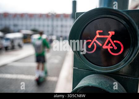 Un cycliste Glovo passant par un feu vert sur la piste cyclable, Lisbonne, Portugal. Banque D'Images