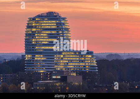Le bâtiment emblématique DUO à Groningen, aux pays-Bas, est illuminé par la lueur chaude du coucher du soleil. Des tons doux d'orange, de rose et de violet remplissent le ciel A. Banque D'Images