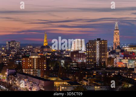 Vue imprenable sur les gratte-ciel de Groningen depuis le Tasmantoren juste après le coucher du soleil. Le ciel brille avec des teintes douces d'orange, de rose et de bleu, tandis que t Banque D'Images
