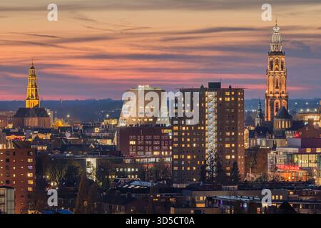 Vue imprenable sur les gratte-ciel de Groningen depuis le Tasmantoren juste après le coucher du soleil. Le ciel brille avec des teintes douces d'orange, de rose et de bleu, tandis que t Banque D'Images
