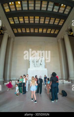 Un groupe de personnes se tient devant le Lincoln Memorial. Le monument est une grande statue du président Lincoln. Les gens prennent des photos A. Banque D'Images