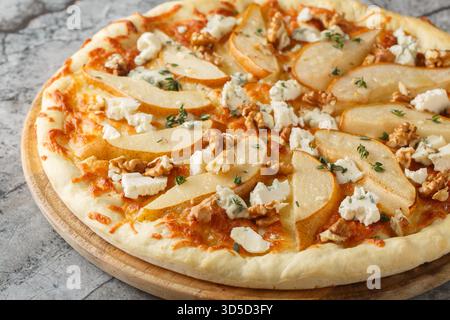 Pizza poire au miel avec fromage bleu, noix, mozzarella et thym gros plan sur une planche de bois sur la table. Horizontal Banque D'Images
