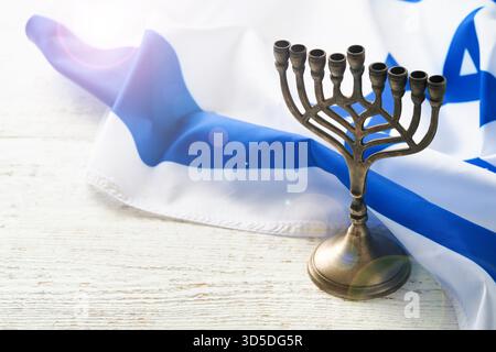 Joyeux Hanukkah. Hanukkah vieille Menorah sur fond du drapeau israélien avec la lumière du soleil ou bokeh sur fond de bois blanc. Image de religion de fête juive Hanukkah fond. Banque D'Images