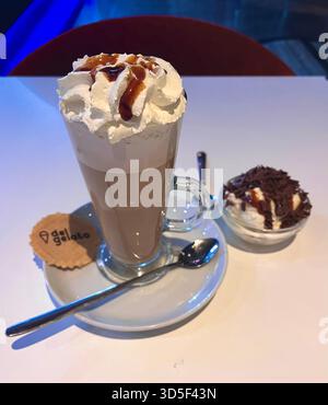 Gros plan d'un chocolat chaud garni de crème fouettée servi dans un café de Hull, en Angleterre. Une image confortable représentant la culture des cafés britanniques Banque D'Images