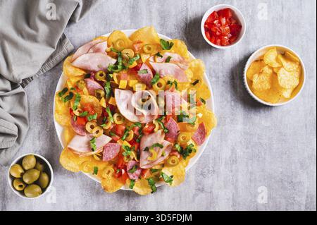 Nachos de charcuterie avec frites, salami, fromage et olives sur une assiette sur une vue de dessus de table Banque D'Images