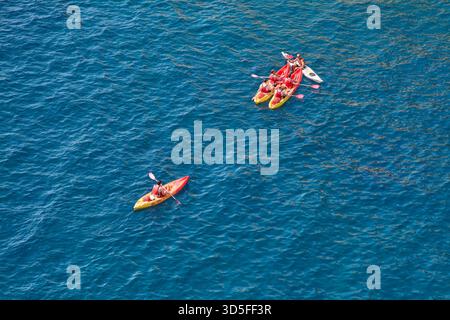 Dubrovnik. Croatie - 15 novembre 2025 : vue aérienne d'un groupe d'amis pagayant des kayaks sur la mer bleue profonde. Le format vertical et Wate pétillant Banque D'Images