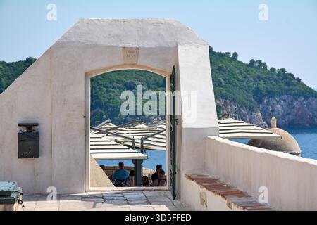 Dubrovnik. Croatie - 15 novembre 2025 : les touristes prennent un verre au célèbre Buza Bar, un café à flanc de falaise accessible par une arche dans la vieille ville Banque D'Images