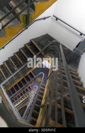 Escalier en colimaçon raide et étroit avec une balustrade en métal, vue d'en haut, montrant le motif répétitif des marches Banque D'Images