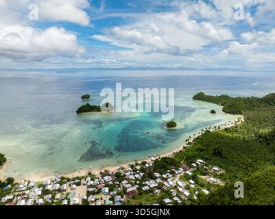 Village près de la plage avec lagon turquoise et récif corallien dans l'eau tropicale claire. Siargao, Philippines. Sugba Blue Lagoon. Banque D'Images