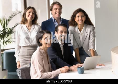 Équipe multiethnique de professionnels des affaires posant au bureau avec des sourires Banque D'Images