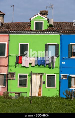 Maison traditionnelle avec façade verte et séchage du linge sur l'île de Burano dans la lagune vénitienne, Italie. Banque D'Images
