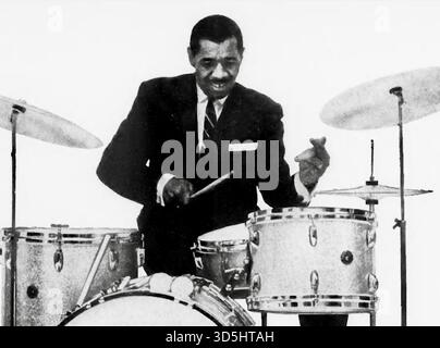 Joseph Rudolph 'Philly Joe' Jones, un batteur de jazz américain influent. Il est surtout connu pour son travail en tant que batteur du premier Quintet 'Great' Miles Davis. Né à Philadelphie en 1923, Jones était un maître de la percussion jazz connu pour son style dynamique et 'électrisant'. Il tourne et enregistre avec le Miles Davis Quintet de 1955 à 1958, contribuant à des albums historiques comme Round Midnight, Cookin' et Milestones. Le jeu de Jones a été très influent, et ses techniques, y compris l'utilisation de rudiments spécifiques de tambour-piège, sont encore étudiées par les étudiants de jazz dans le monde entier. Banque D'Images