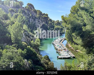 Cassis, France, 30 septembre 2025 : la calanque de Port miou expose des bateaux amarrés dans une crique tranquille entourée d'arbres verdoyants Banque D'Images