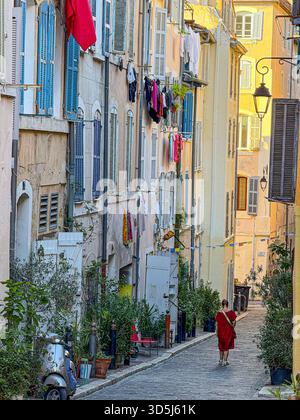 Marseille , France, 10 octobre 2025 : femme marchant le long d'une charmante vieille rue du quartier historique du panier de marseille Banque D'Images