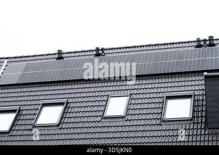 La maison moderne dispose de panneaux solaires et de puits de lumière, mettant en valeur un design respectueux de l'environnement et des solutions d'énergie renouvelable Banque D'Images