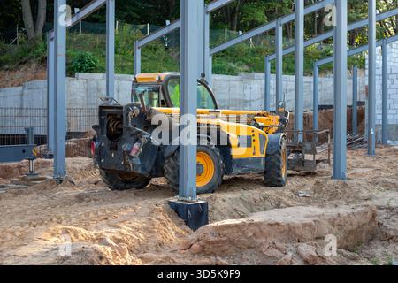 Chariot télescopique sur un chantier de construction après le travail. EQUIPEMENT de construction pour le chargement. Chargeur frontal pour le levage de charges, un chariot élévateur à une construction Banque D'Images