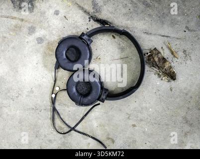 Détail de vieux écouteurs cassés dans la poubelle, recyclage Banque D'Images