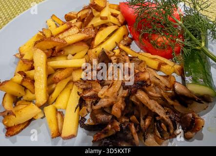 Service de pommes de terre poêlées avec du bœuf, des champignons et des oignons Banque D'Images