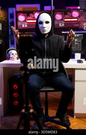 Hacker caché dans le repaire souterrain envoyant un ultimatum aux gouvernements étrangers, piratant des systèmes. Un programmeur masqué et malhonnête menace de représailles contre une cible militaire si ses conditions ne sont pas remplies Banque D'Images