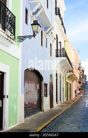 Une charmante scène de rue présente des bâtiments colorés avec des balcons ornés bordant une rue pavée. Banque D'Images