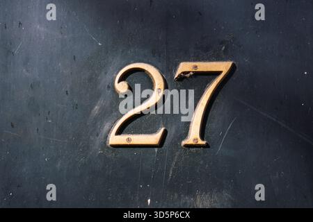 Maison numéro 27 sur mur de briques extérieur. Vue de face, gros plan, personne Banque D'Images