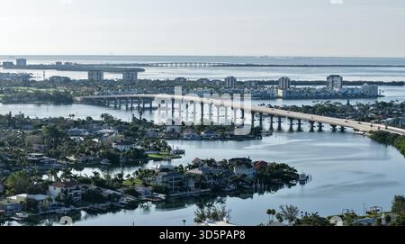 Vue aérienne d'un long pont s'étendant sur les eaux chatoyantes reliant des îles parsemées de bâtiments sous un ciel brumeux, situé Pete Beach, Floride, Banque D'Images