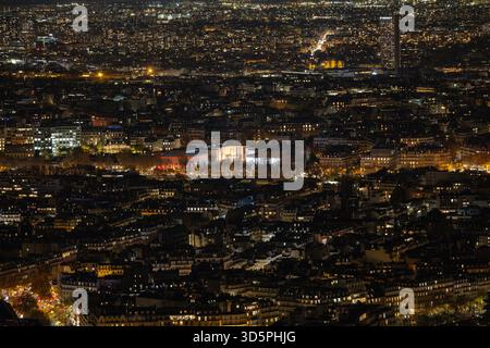 Vue aérienne d'une tapisserie de lumières scintillantes de la ville, illuminant l'étendue urbaine sous la silhouette de la Tour Eiffel, un phare dans le velours Banque D'Images