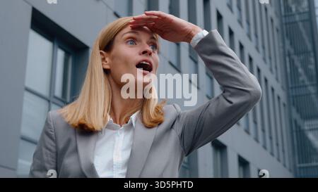 Femme d'affaires adulte caucasienne jetant un coup d'œil saluant bonjour près de l'immeuble de bureaux bâtiment d'entreprise bâtiment d'entreprise d'âge moyen femme d'affaires en attente de réunion mis Banque D'Images