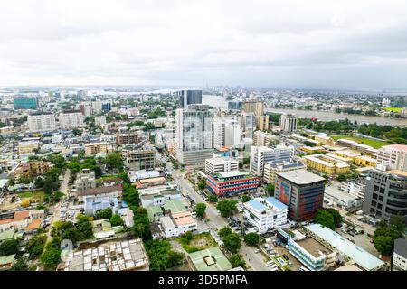 Vue aérienne de l'architecture moderne de la ville atteignant le ciel, contrastant avec les espaces verts et les voies navigables tissant à travers le paysage urbain Banque D'Images