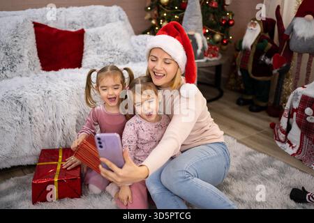 Mère et filles prenant selfie avec des cadeaux de Noël Banque D'Images