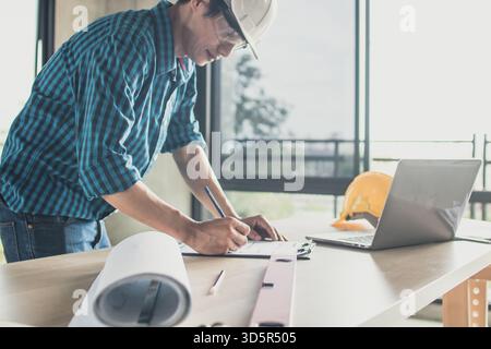 ingénieur travaillant sur ordinateur portable avec impression bleue dans le bureau Banque D'Images