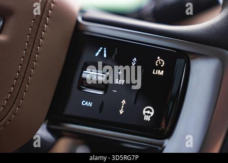 Commandes au volant d'un VUS de luxe avec boutons d'aide au conducteur allumés Banque D'Images
