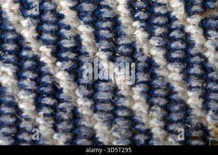 Gros plan d'un tissu tissé texturé bleu et blanc, avec des rayures audacieuses et des fibres détaillées, idéal pour les arrière-plans, les textiles et le design d'intérieur c Banque D'Images