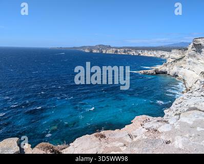 Vue sur la ville médiévale de Bonifacio avec sa côte calcaire blanche et sa mer turquoise d'un bleu profond et intense, ensoleillée et bleue Banque D'Images